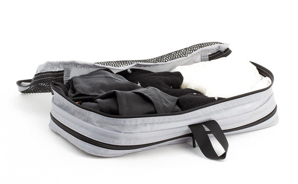 A few pairs of undergarments folded in a Northwest Sky (light grey) Aether Small Laundry Aeronaut 45 Packing Cube.
